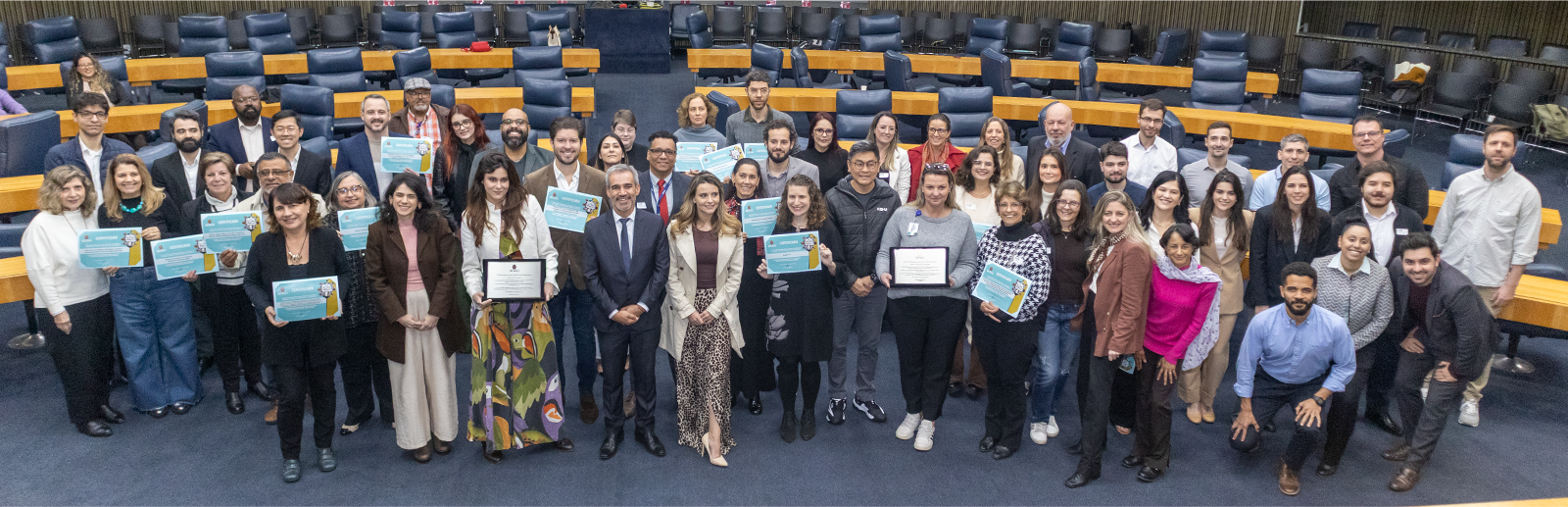Varias pessoas no auditório segurando um certificado
