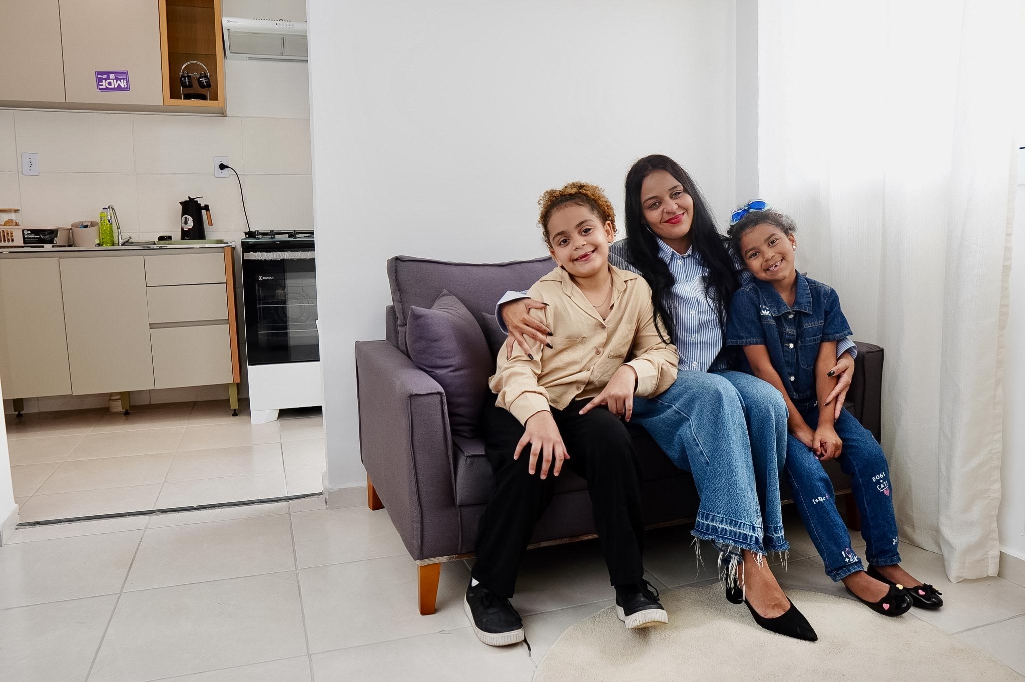 Mãe e suas duas filhas em seu novo apartamento no Residencial Forte do Rio Branco