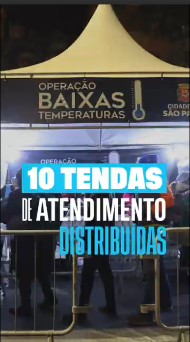 A imagem mostra uma tenda branca montada à noite, com uma faixa preta na parte superior onde se lê "OPERAÇÃO BAIXAS TEMPERATURAS" e o brasão da cidade de São Paulo. Em frente à tenda, há grades de proteção e pessoas reunidas, algumas usando casacos. Sobre a foto, há um texto em destaque: "10 TENDAS DE ATENDIMENTO DISTRIBUÍDAS", indicando uma ação de assistência durante o frio.