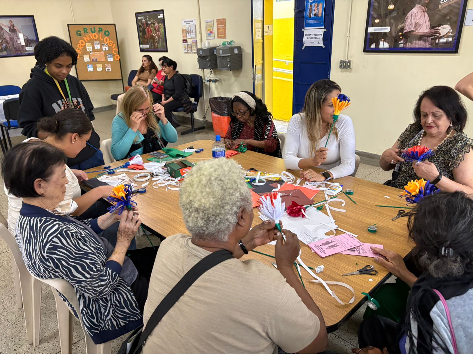 Idosas participando de atividade de artesanato reciclado.