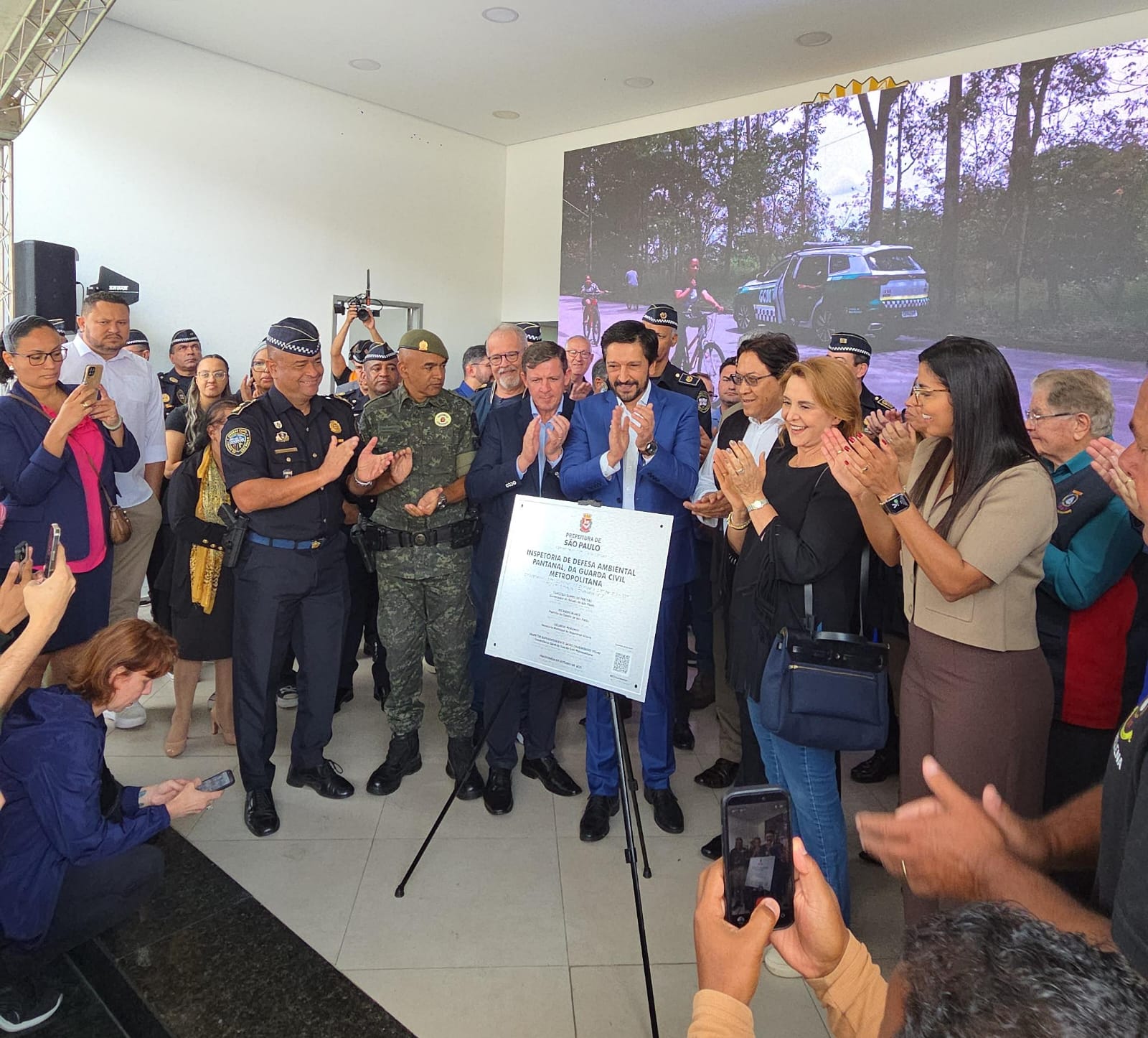 Prefeito de São Paulo ao centro e diversas figuras políticas da região em volta aplaudindo a placa de inauguração Inspetoria de Defesa Ambiental Pantanal.
